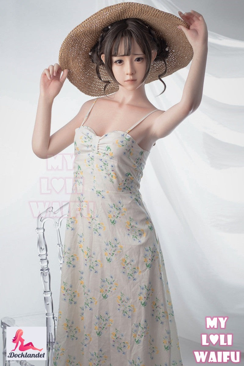 Nanami silikonsexdocka 150 cm, poserar i vit spetsoutfit med armarna uppdragna, detaljerat huvud och naturlig kroppshållning.